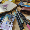 Aquarell-Palette, Notizbuch mit Blumenzeichnung und Stifte