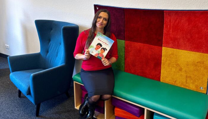 Shlica Weiß hält ihr Buch "Reilo und Reili"