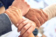 Vier Hände, die sich umfassen