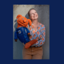 Frau mit oranger Handpuppe im Weltall-Anzug