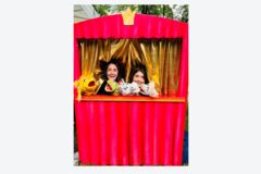 Zwei Personen, die ein Puppentheater vorspielen