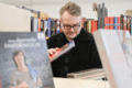 Mann stöbert in Bücherflohmarkt