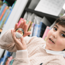 Junge hält Figur in Kamera