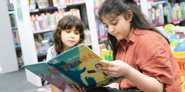 Schulkinder lesen gemeinsam ein Buch