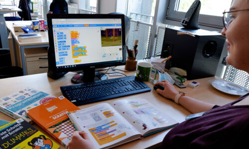 Person arbeite mit Scratch am PC