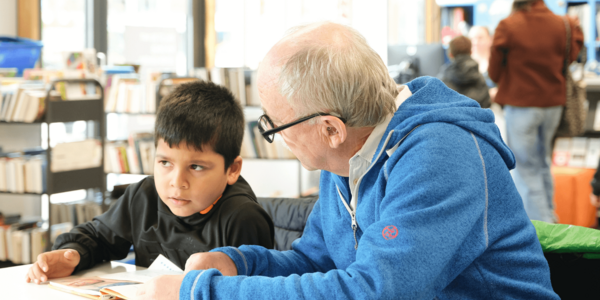 Eine Vorleserin liest Kindern ein Buch vor