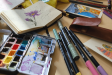 Aquarell-Palette, Notizbuch mit Blumenzeichnung und Stifte