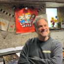 Mann (Steffen Hand) steht in einer Werkstatt und lächelt in die Kamera.