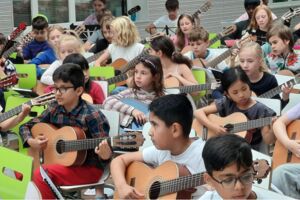 Kinder spielen Gitarre.