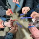 viele Hände halten 3D-gedruckte Schriftzüge