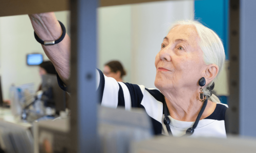 ältere Dame stöbert in der Bücherhalle