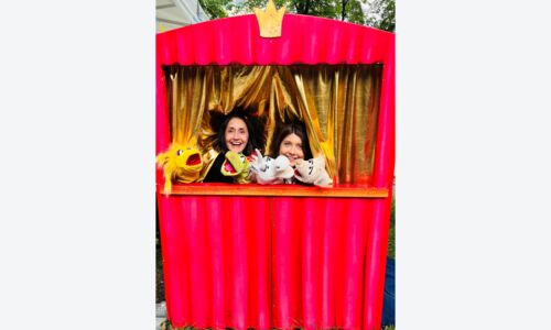 Zwei Personen, die ein Puppentheater vorspielen