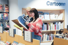 zwei Frauen stöbern bei den Comics in der Zentralbibliothek