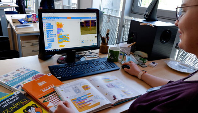 Person arbeite mit Scratch am PC
