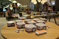 Thymio Roboter mit USB Sticks und Fernbedienung auf einem Tisch