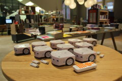 Thymio Roboter mit USB Sticks und Fernbedienung auf einem Tisch