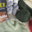 Strickwolle, Stricknadeln und zwei Bücher über Stricken