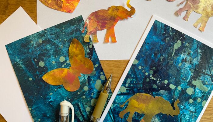 Zwei blaue Grußkarten mit goldenem Schmetterling und Elefant