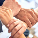 Vier Hände, die sich umfassen