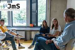 Eine Gruppe sitz im Stuhlkreis und unterhält sich.