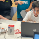Junge sitzt vor einem Laptop und Makey Makey