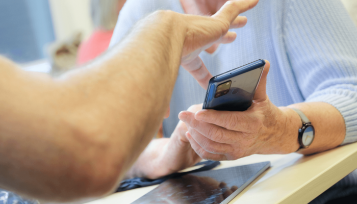 Silber & Smart Workshop wo Person Dinge am Handy erklärt bekommt