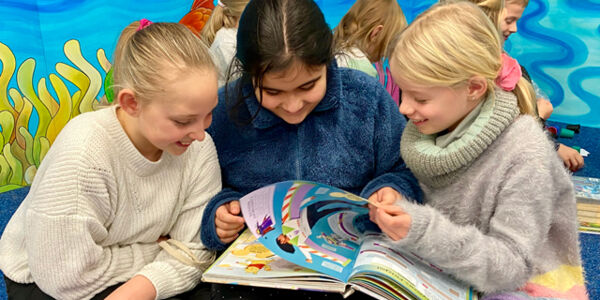 Drei Mädchen betrachten ein Buch