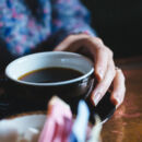 Person hält eine Tasse Kaffee.