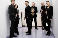Sechs Personen in Abendgarderobe mit Blasinstrumenten