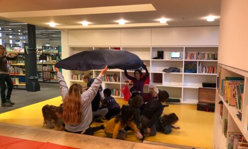 Personen und Kinder spielen in der Kinderbibliothek