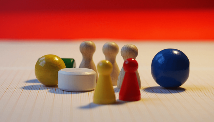 Hölzerne Spielfiguren auf einem Spielbrett.