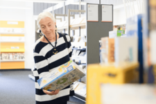 ältere Dame stöbert in der Bücherhalle