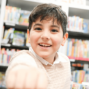 fröhlicher Junge in der Bücherhalle
