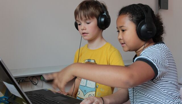 Kinder mit Kopfhörer und Laptop