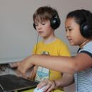 Kinder mit Kopfhörer und Laptop