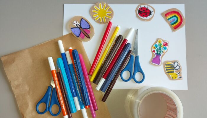 Stifte, Scheren und Klebeband, mit denen Aufkleber gestaltet wurden.