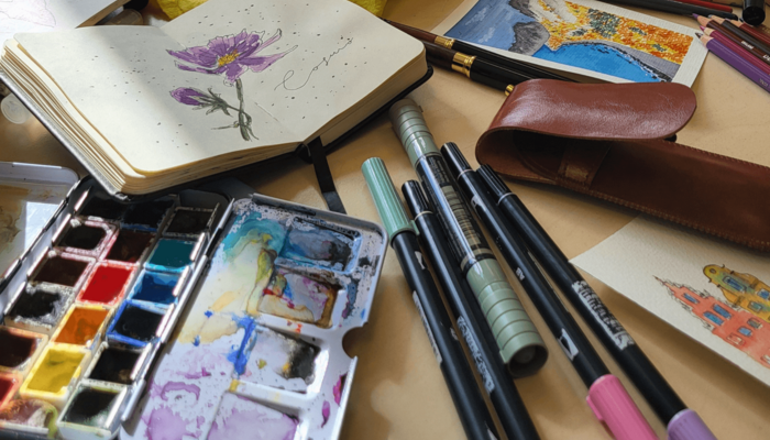 Aquarell-Palette, Notizbuch mit Blumenzeichnung und Stifte