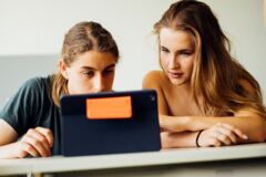 Zwei Jugendliche recherchieren am Bildschirm