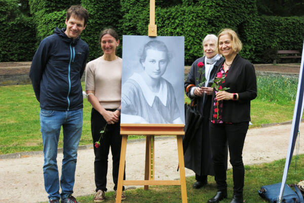 Ein Mann und drei Frauen gruppiert um ein Bild