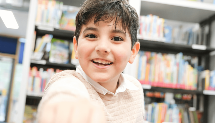fröhlicher Junge in der Bücherhalle