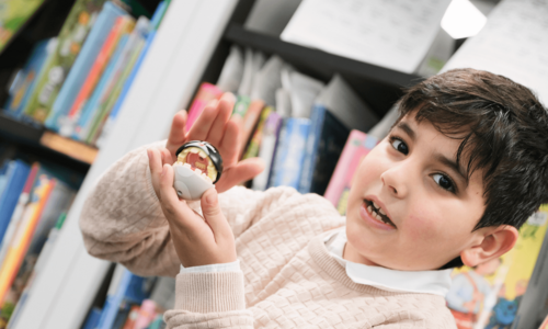 Junge hält Figur in Kamera