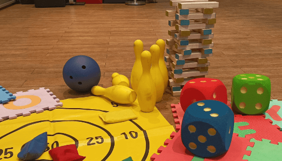 Verschiedene Kinderspiele auf dem Boden verteilt.