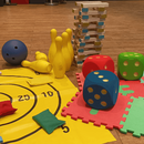 Verschiedene Kinderspiele auf dem Boden verteilt.