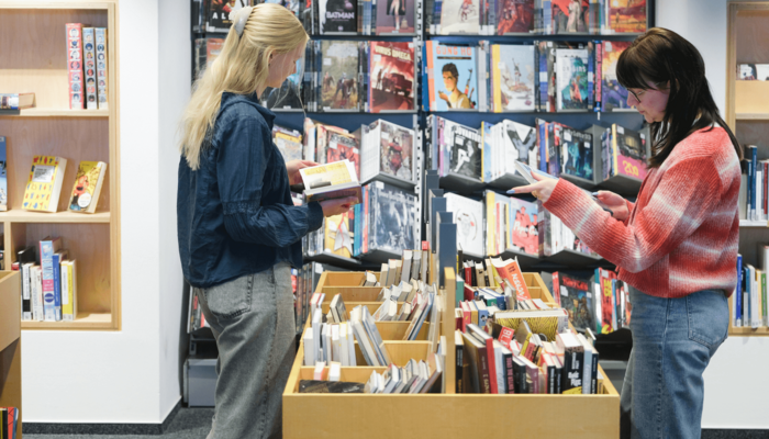 Zwei Personen stöbern Comics in der Zentralbibliothek