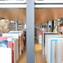 Zwei Personen stöbern Bücher in der Zentralbibliothek