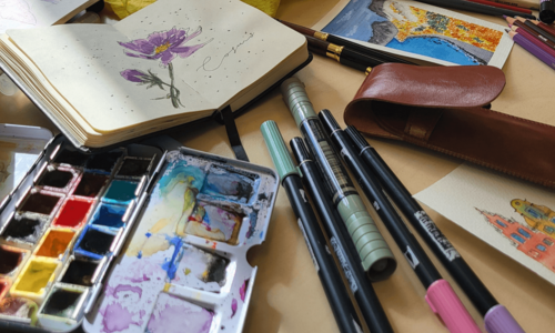 Aquarell-Palette, Notizbuch mit Blumenzeichnung und Stifte