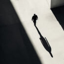 Mann im Lichtstrahl und sein Schatten in schwarz-weiss