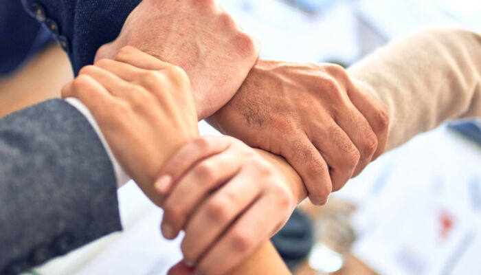 Vier Hände, die sich umfassen