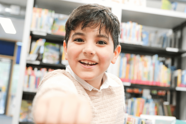 fröhlicher Junge in der Bücherhalle