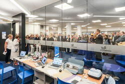 Im Vordergrund Geräte aus dem MakerLab im Alstertal, im Hintergrund hält Jana Schiedek ein Grußwort zur Eröffnung